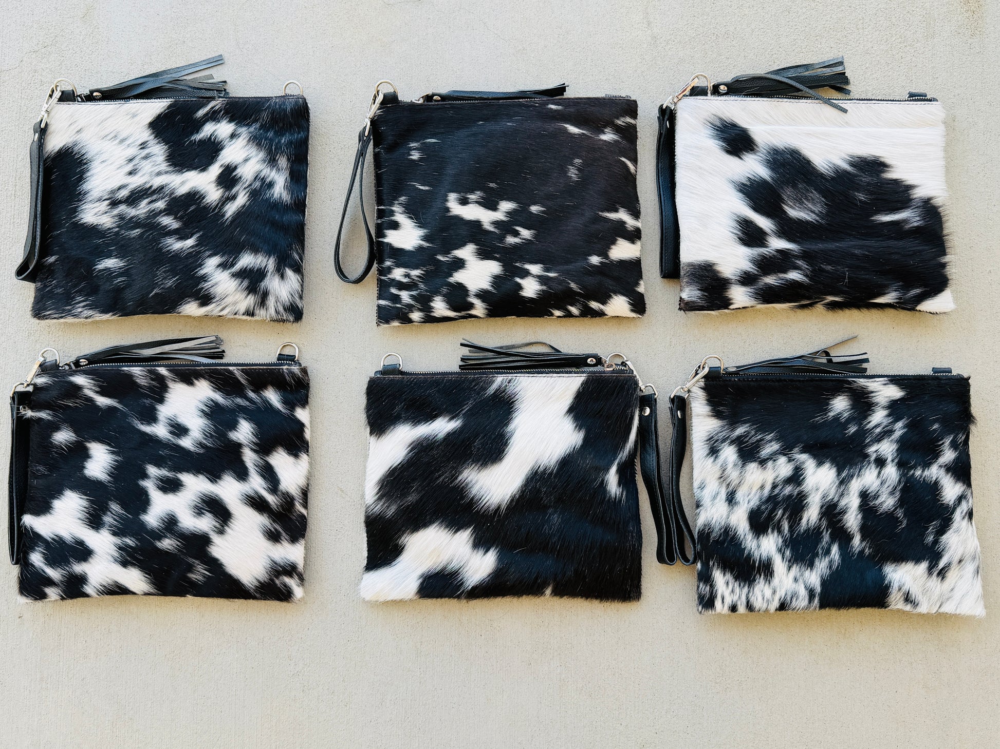 Handcrafted genuine cowhide crossbody purse with hair-on-hide front, leather tassel, adjustable strap, and western leather design for everyday wear, travel, rodeos, and concerts.