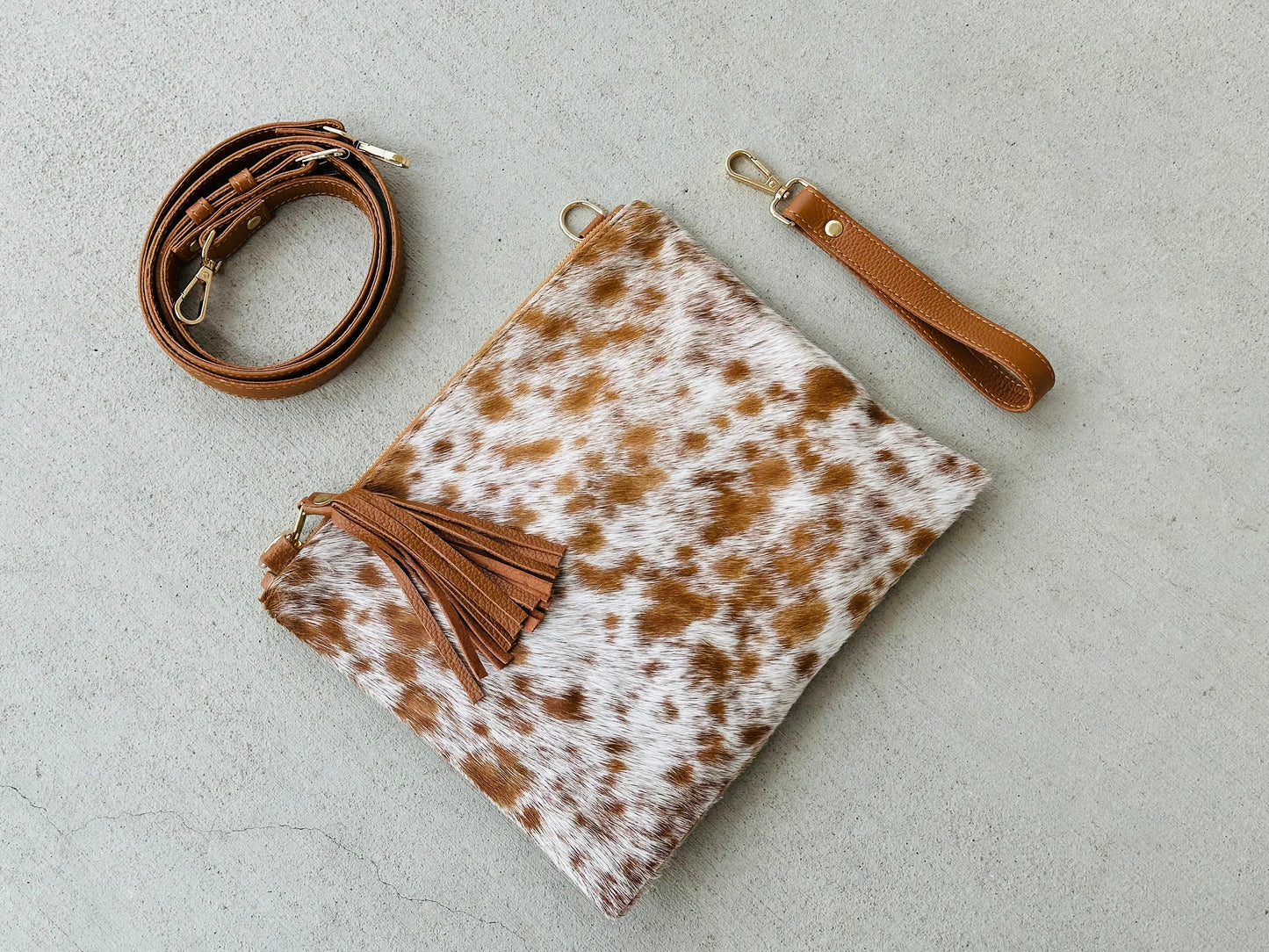 Handcrafted genuine cowhide crossbody purse with hair-on-hide front, leather tassel, adjustable strap, and western leather design for everyday wear, travel, rodeos, and concerts.