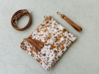 Handcrafted genuine cowhide crossbody purse with hair-on-hide front, leather tassel, adjustable strap, and western leather design for everyday wear, travel, rodeos, and concerts.
