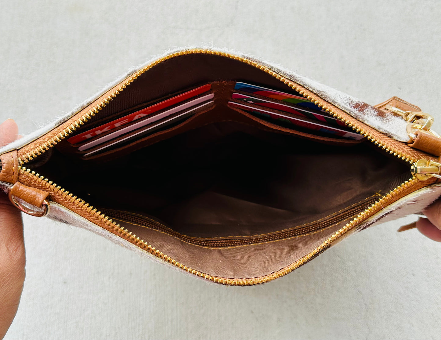 Handcrafted genuine cowhide crossbody purse with hair-on-hide front, leather tassel, adjustable strap, and western leather design for everyday wear, travel, rodeos, and concerts.