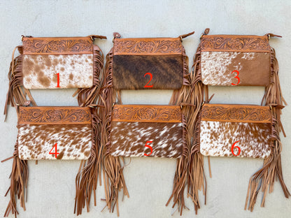 Handcrafted genuine cowhide crossbody bag with floral tooled leather, long leather fringe, adjustable strap, and zip-top closure for western, rodeo, and everyday style.