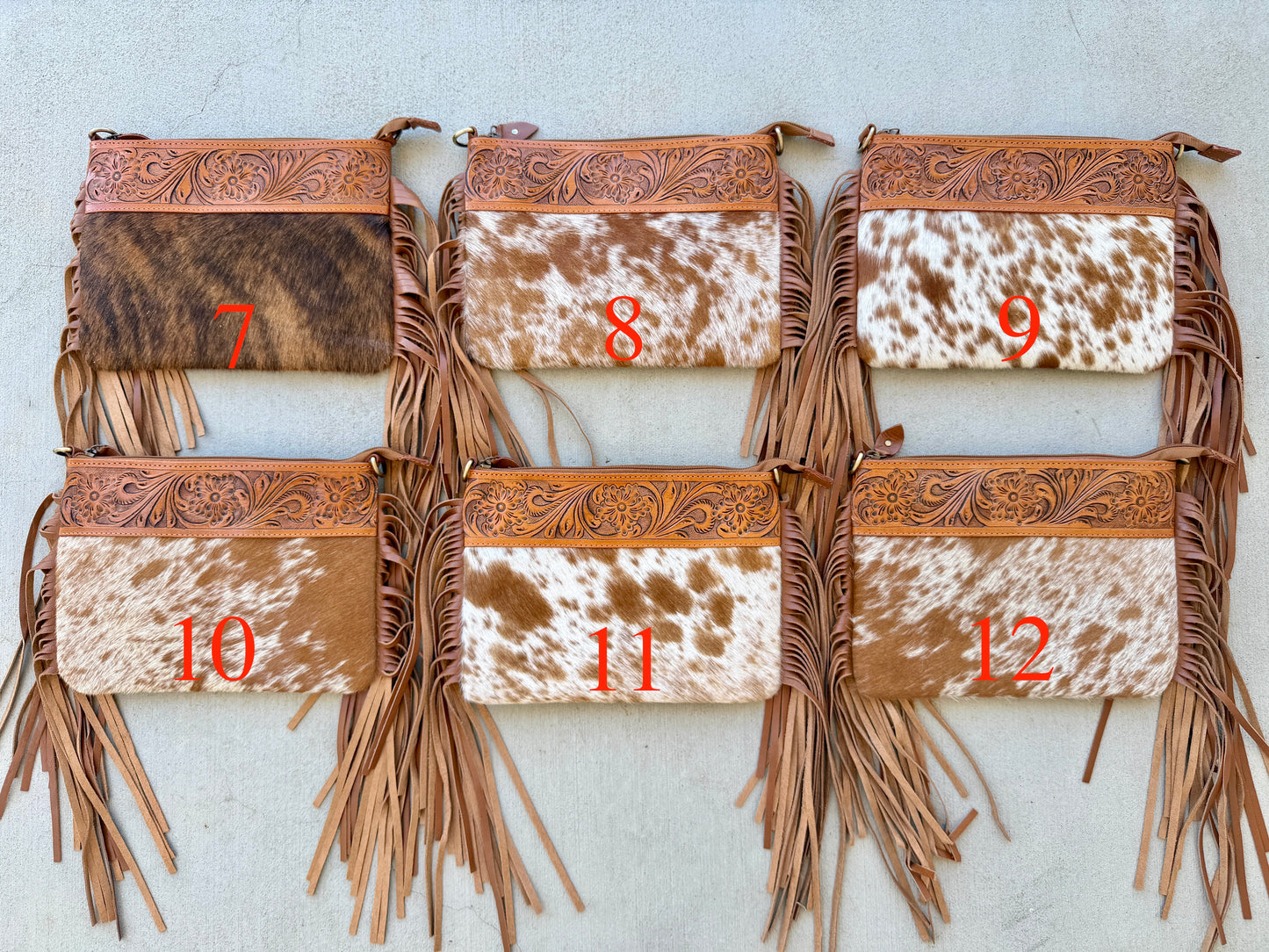 Handcrafted genuine cowhide crossbody bag with floral tooled leather, long leather fringe, adjustable strap, and zip-top closure for western, rodeo, and everyday style.