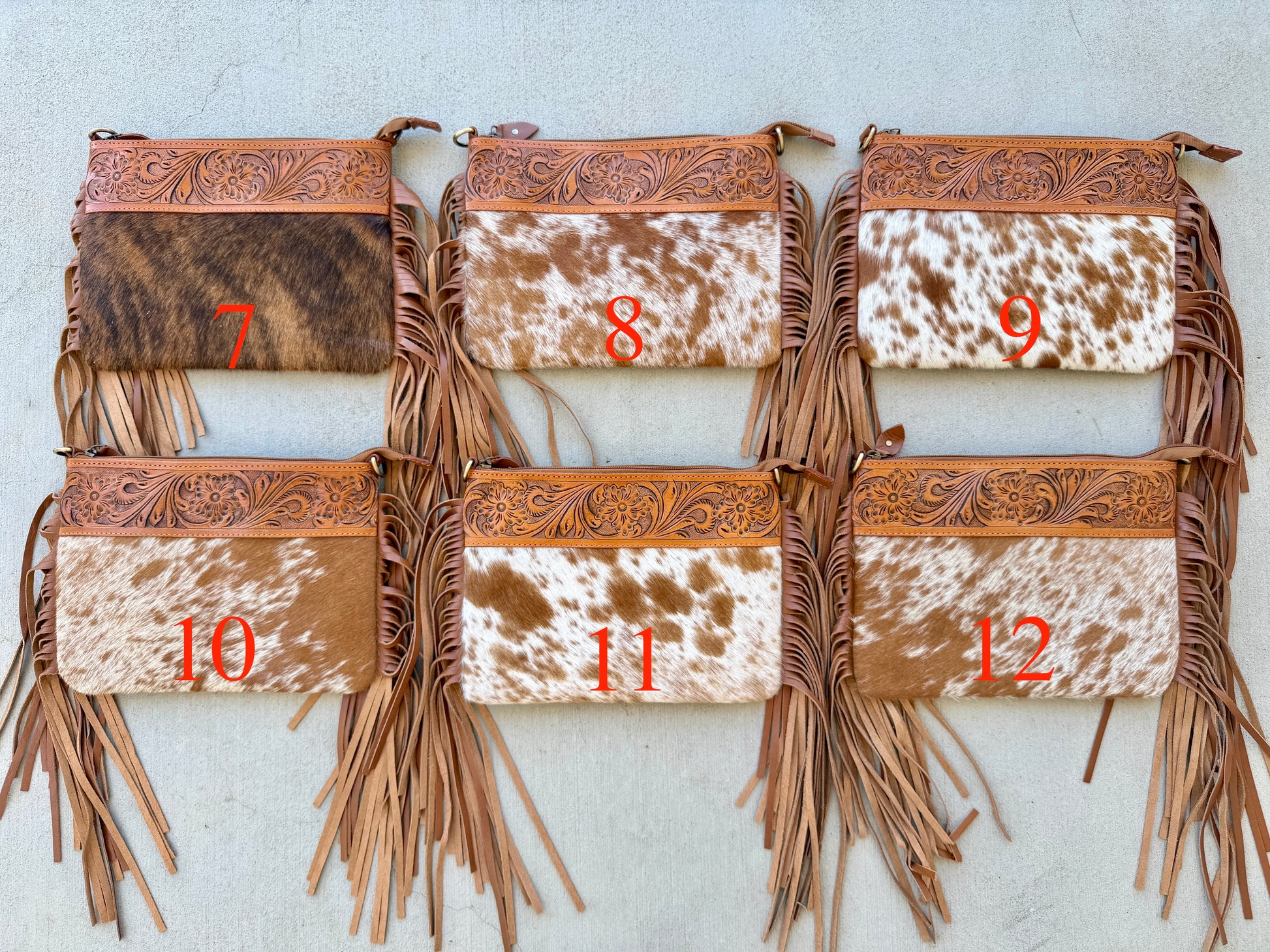 Handcrafted genuine cowhide crossbody bag with floral tooled leather, long leather fringe, adjustable strap, and zip-top closure for western, rodeo, and everyday style.