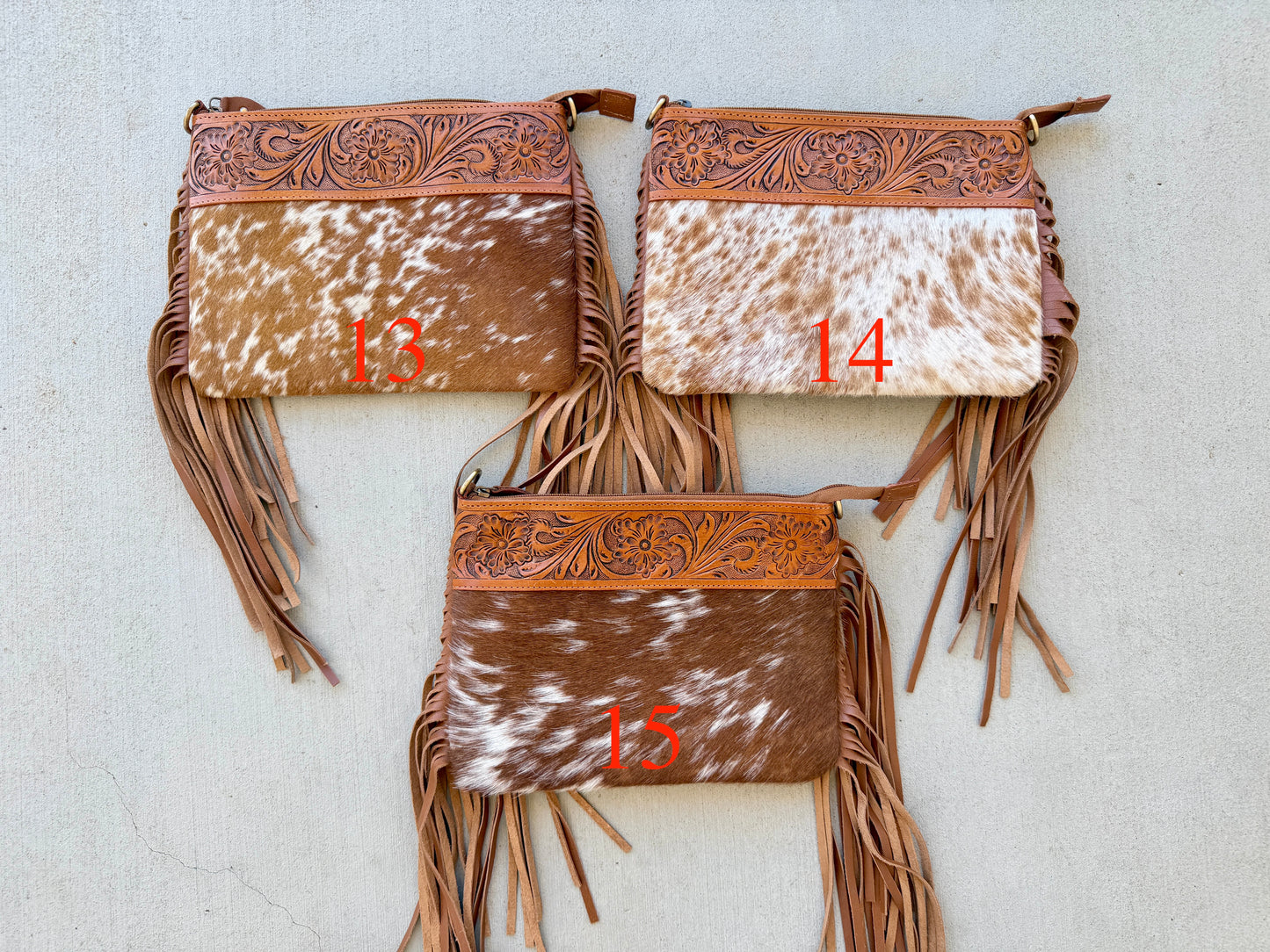 Handcrafted genuine cowhide crossbody bag with floral tooled leather, long leather fringe, adjustable strap, and zip-top closure for western, rodeo, and everyday style.