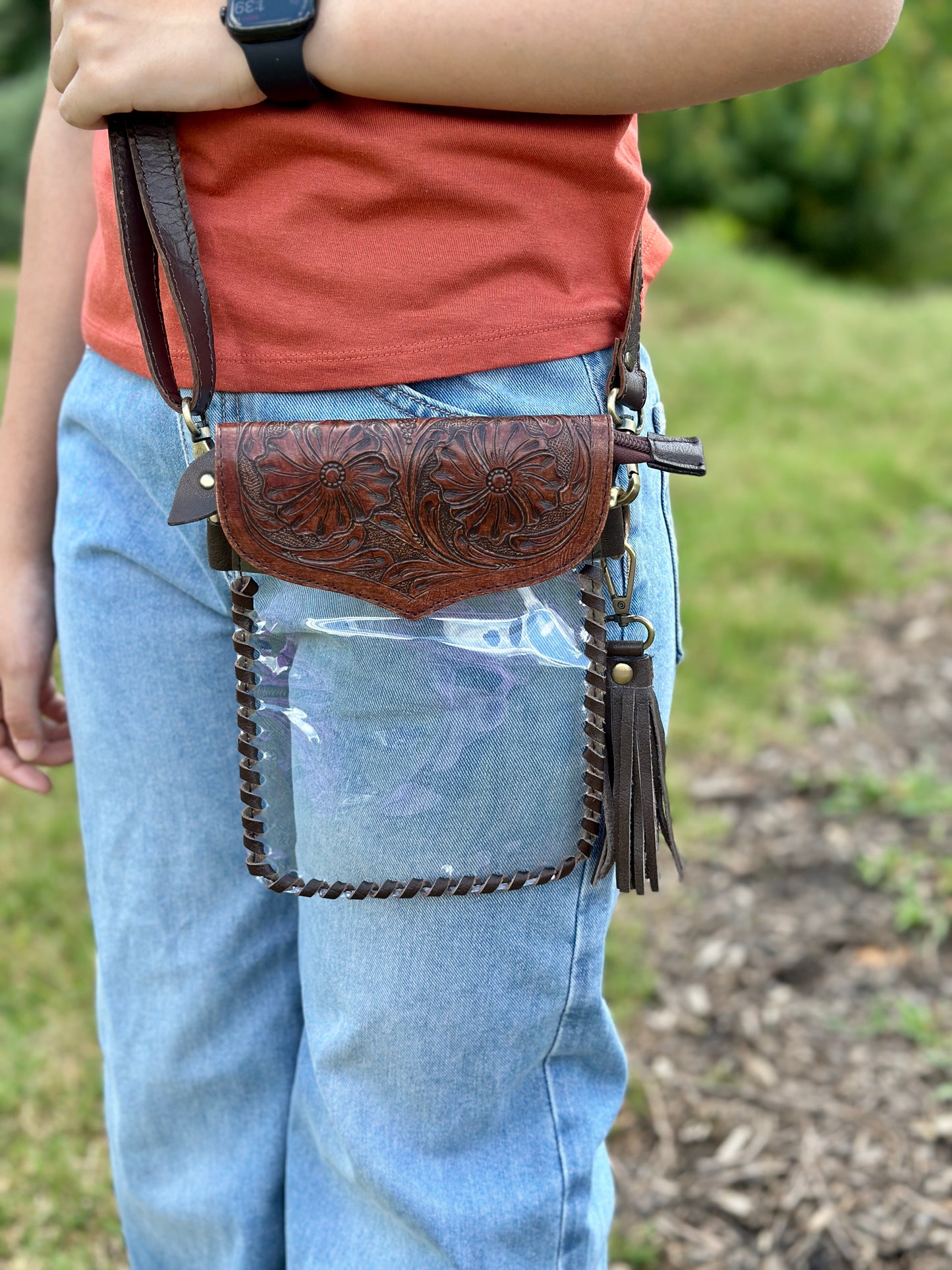 Handcrafted clear crossbody bag with genuine tooled leather accents. Stadium-approved western concert purse, perfect for rodeos, games, festivals, and everyday use.
