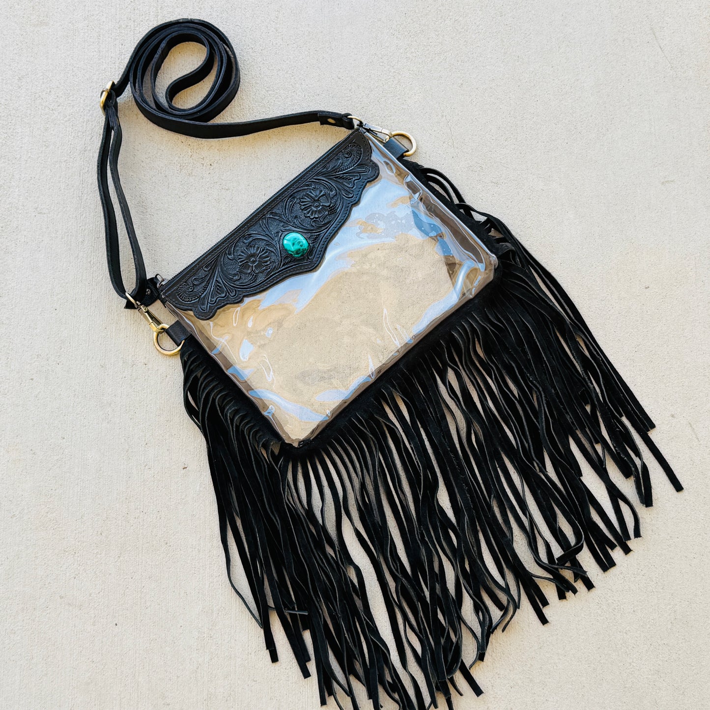 Stadium-approved clear western crossbody bag with genuine leather fringe, turquoise stone accent, adjustable strap, and zip closure for concerts, rodeos, and festivals.