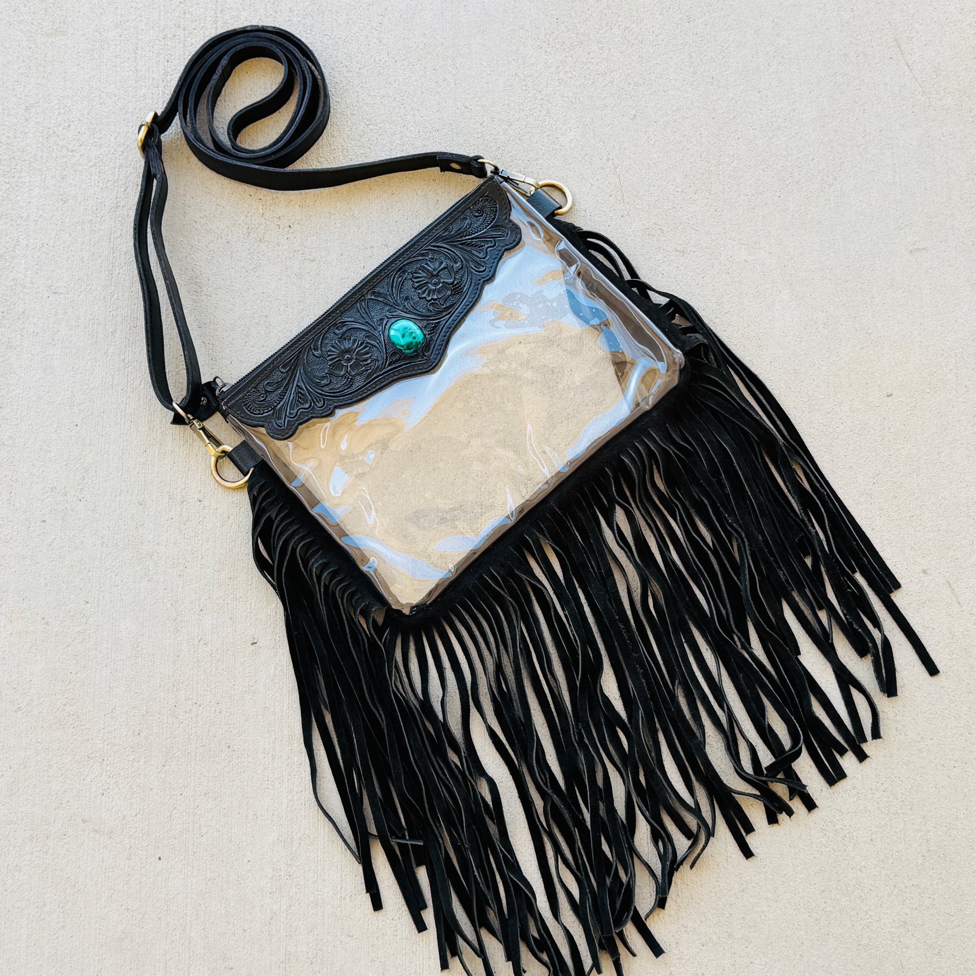 Stadium-approved clear western crossbody bag with genuine leather fringe, turquoise stone accent, adjustable strap, and zip closure for concerts, rodeos, and festivals.