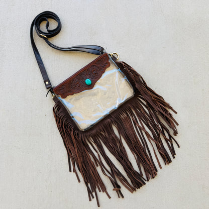 Stadium-approved clear western crossbody bag with genuine leather fringe, turquoise stone accent, adjustable strap, and zip closure for concerts, rodeos, and festivals.