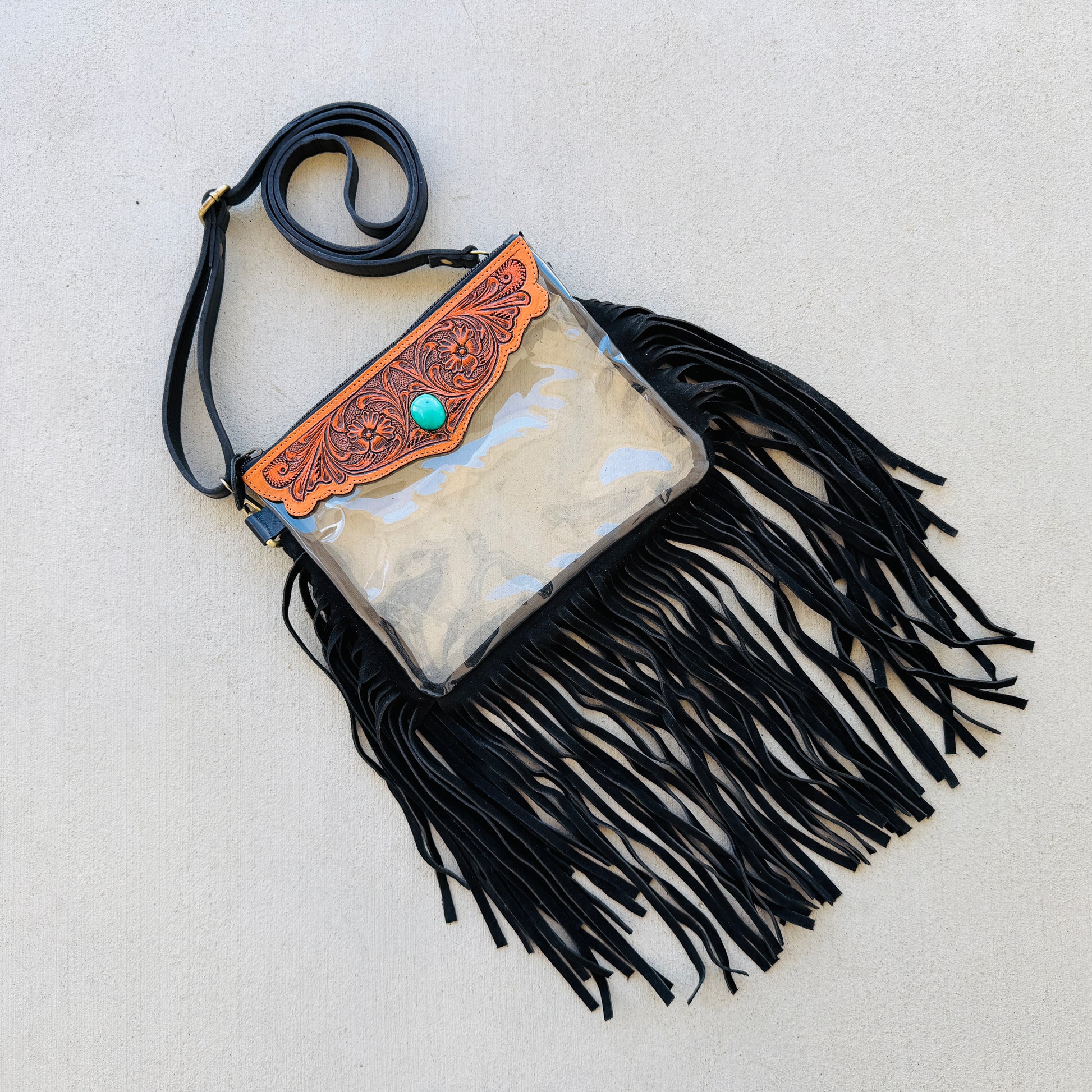 Stadium-approved clear western crossbody bag with genuine leather fringe, turquoise stone accent, adjustable strap, and zip closure for concerts, rodeos, and festivals.