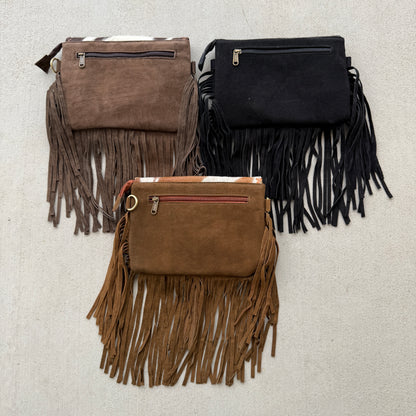 Handcrafted genuine cowhide fringe crossbody purse with whipstitched flap, leather tassel, adjustable strap, and western hair-on-hide design for rodeos, concerts, and everyday wear.