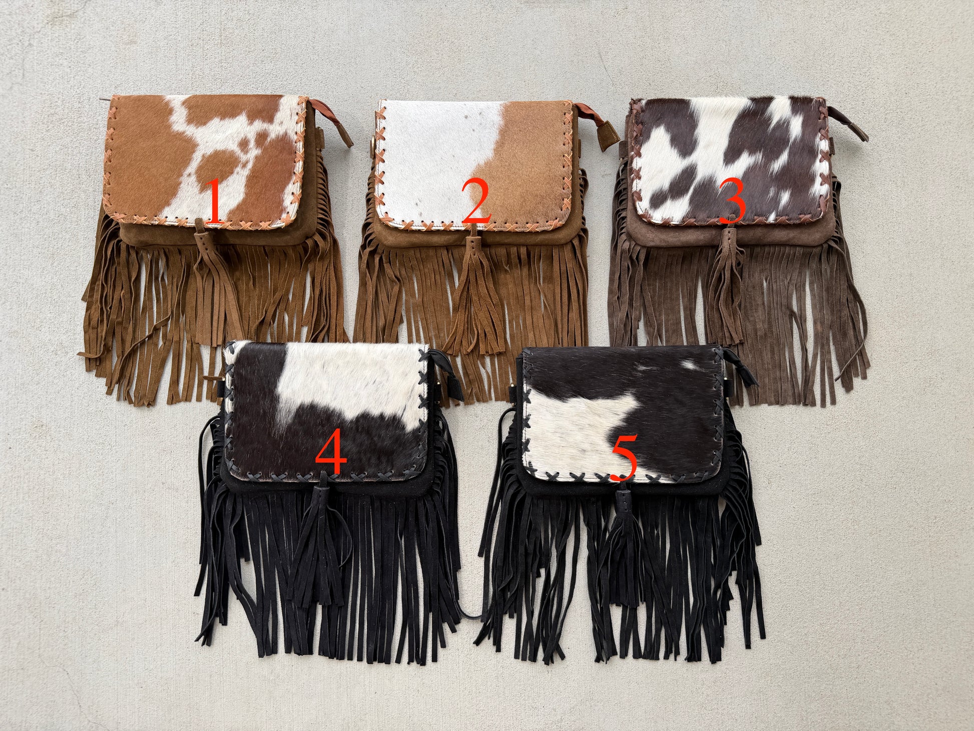 Handcrafted genuine cowhide fringe crossbody purse with whipstitched flap, leather tassel, adjustable strap, and western hair-on-hide design for rodeos, concerts, and everyday wear.