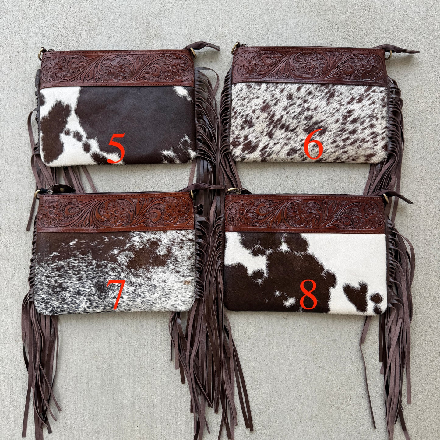 Handcrafted genuine cowhide crossbody bag with floral tooled leather, long leather fringe, adjustable strap, and zip-top closure for western, rodeo, and everyday style.