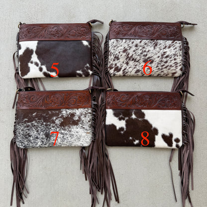 Handcrafted genuine cowhide crossbody bag with floral tooled leather, long leather fringe, adjustable strap, and zip-top closure for western, rodeo, and everyday style.