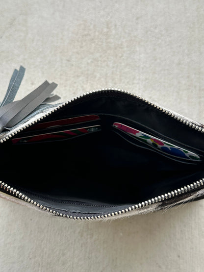 Handcrafted genuine cowhide crossbody purse with hair-on-hide front, leather tassel, adjustable strap, and western leather design for everyday wear, travel, rodeos, and concerts.