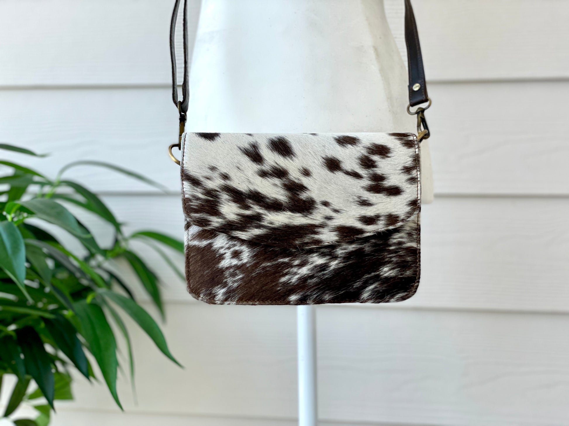 Handcrafted genuine cowhide leather crossbody purse with adjustable strap, western hair-on-hide handbag for rodeos, festivals, concerts, and everyday wear.