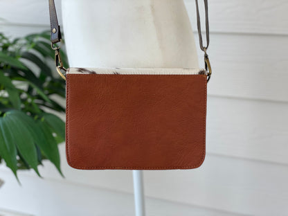 Handcrafted genuine cowhide leather crossbody purse with adjustable strap, western hair-on-hide handbag for rodeos, festivals, concerts, and everyday wear.