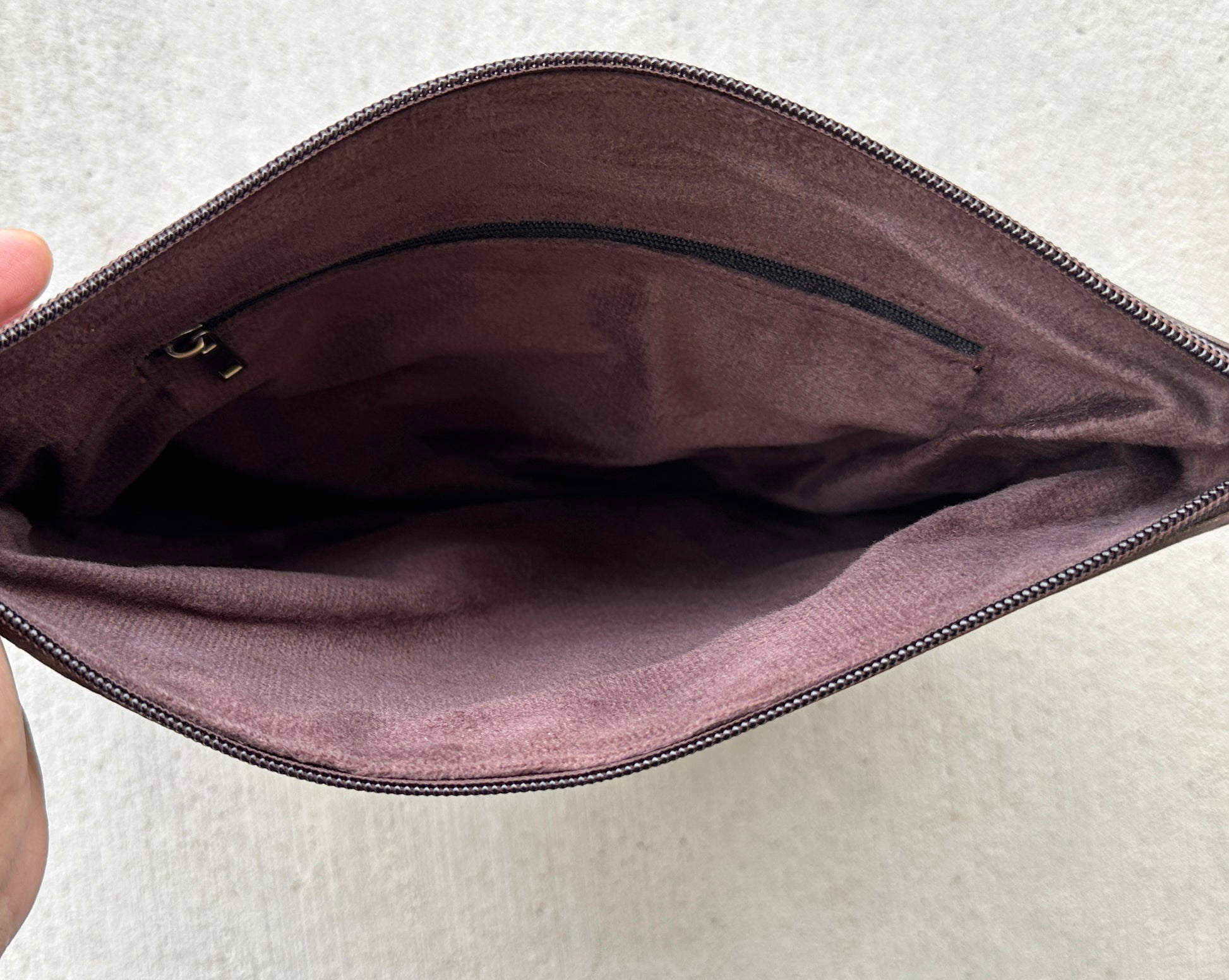 Handcrafted genuine cowhide crossbody purse with floral tooled leather zipper accent, adjustable leather strap, and western hair-on-hide design for everyday wear and rodeos.
