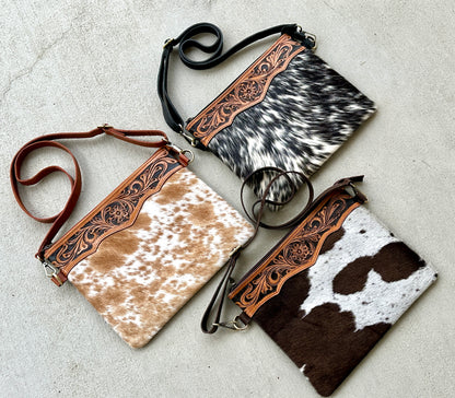 Handcrafted genuine cowhide crossbody purse with floral tooled leather zipper accent, adjustable leather strap, and western hair-on-hide design for everyday wear and rodeos.