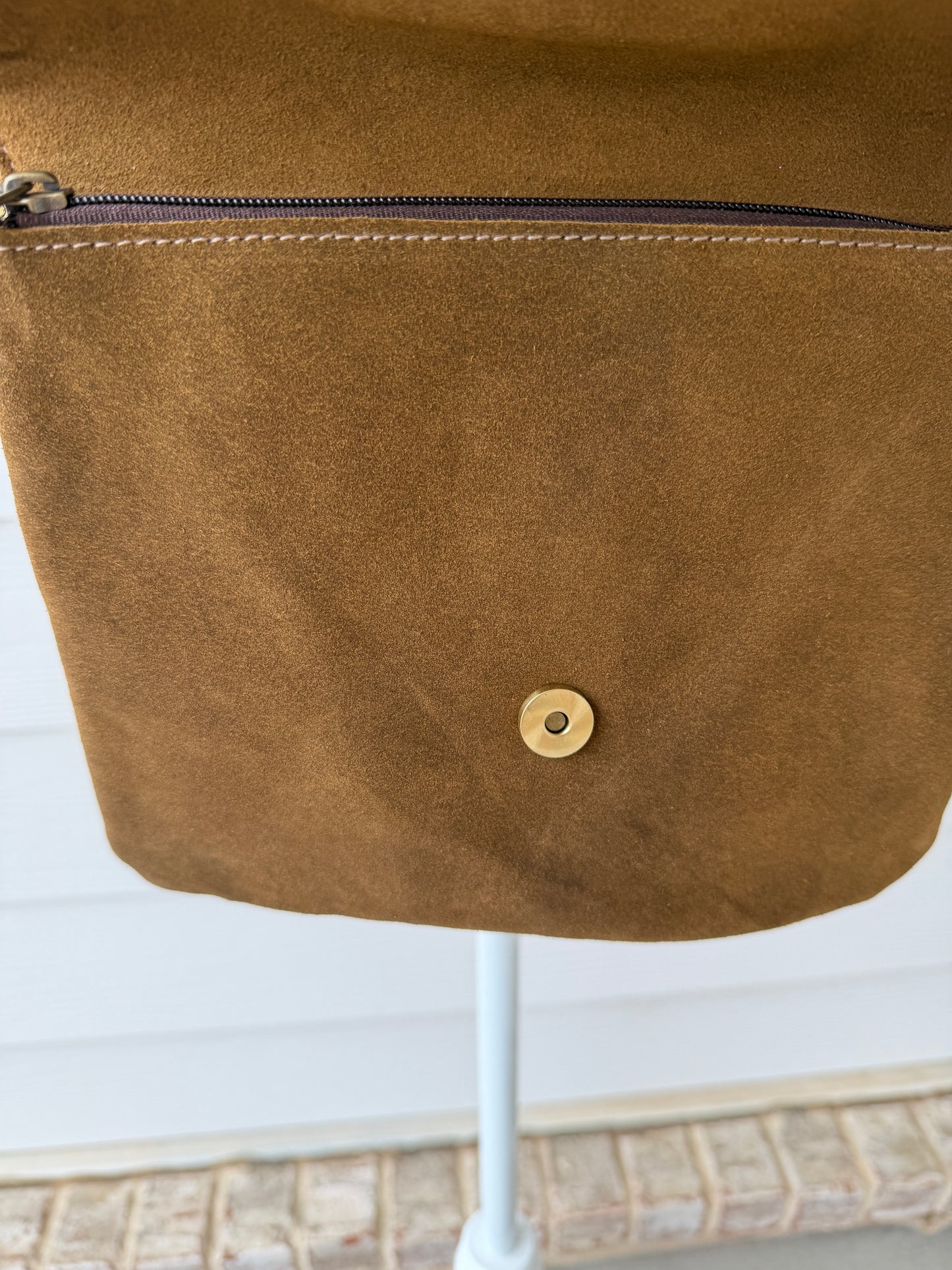 Handcrafted western cowhide crossbody bag with turquoise stone concho, whipstitched envelope flap, long leather fringe, and adjustable strap for rodeos, concerts, and everyday wear.