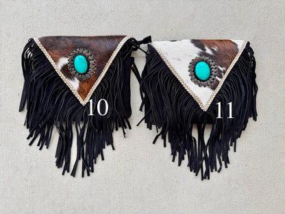 Handcrafted western cowhide crossbody bag with turquoise stone concho, whipstitched envelope flap, long leather fringe, and adjustable strap for rodeos, concerts, and everyday wear.