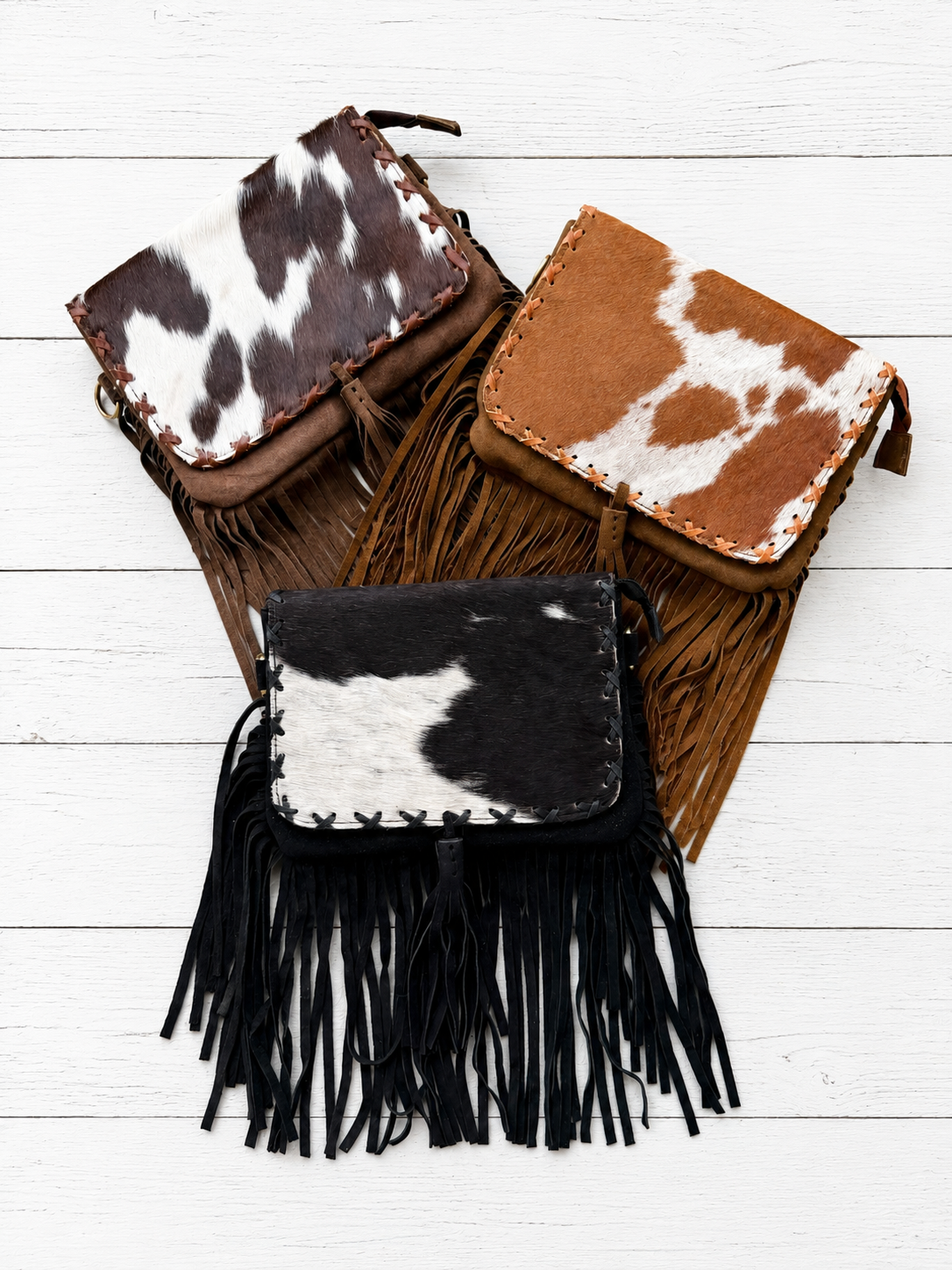 Handcrafted genuine cowhide fringe crossbody purse with whipstitched flap, leather tassel, adjustable strap, and western hair-on-hide design for rodeos, concerts, and everyday wear.