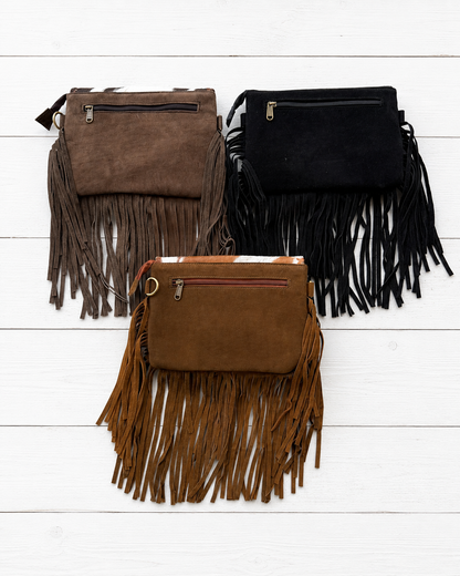 Handcrafted genuine cowhide fringe crossbody purse with whipstitched flap, leather tassel, adjustable strap, and western hair-on-hide design for rodeos, concerts, and everyday wear.