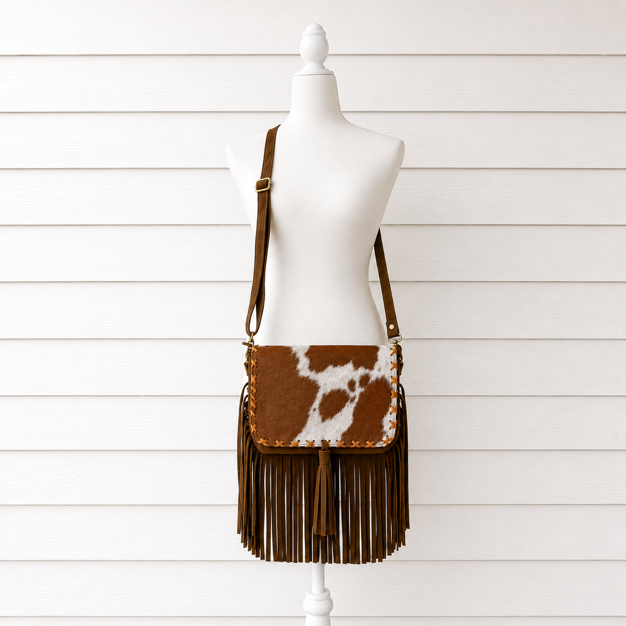 Handcrafted genuine cowhide fringe crossbody purse with whipstitched flap, leather tassel, adjustable strap, and western hair-on-hide design for rodeos, concerts, and everyday wear.